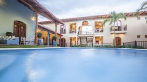 A hotel with a swimming pool, multiple balconies, and a covered outdoor seating area. - Paraiso Granada (Granada)