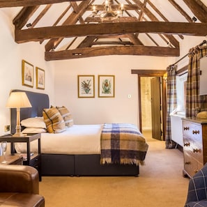 A bedroom with a bed, bedside table, lamp, and a dresser with drawers. - Minster Mill Hotel and Spa (Witney)