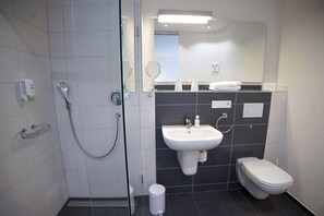 A modern bathroom with a glass shower enclosure, a white sink, and a toilet. - Hotel Go2bed Weil Basel (Weil am Rhein)