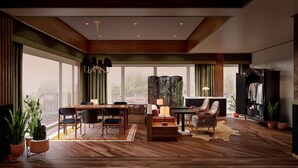 Un vaste espace de vie doté d’un plancher en bois, d’une table à manger et de chaises, d’un canapé, d’un paravent décoratif et d’un téléviseur.