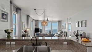 Een moderne keuken met granieten aanrecht, een dubbele spoelbak en uitzicht op de stad.
