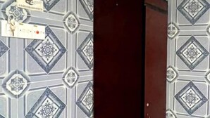 A room with patterned wallpaper, a dark-colored wardrobe, and a tiled floor. - ARK Hotel Batu Caves (Batu Caves)