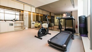 A modern hotel room with a treadmill, exercise bike, and a small kitchen area. - JI Hotel Shanghai Anting Metro Station (Shanghai)