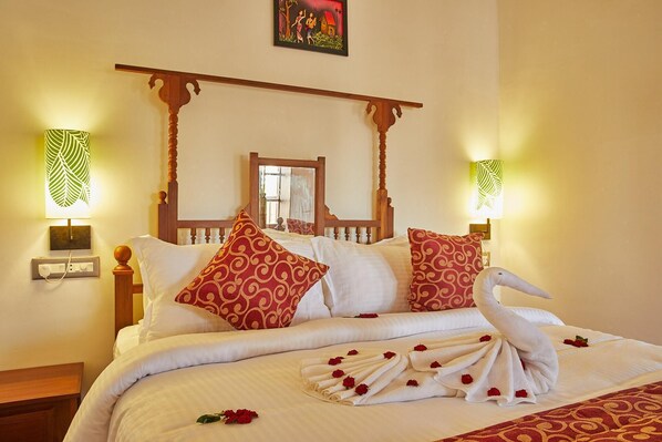 A bed with a canopy, decorative pillows, and a swan towel arrangement. - Villa Du Ocean (Puducherry)