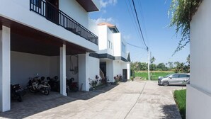 A modern two-story house with a covered driveway and a car parked outside. - Sujiwa Ubud Retreat (Sukawati)