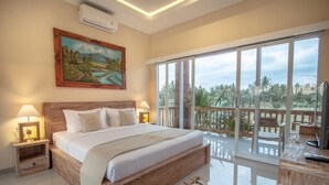 A bedroom with a large bed, two bedside tables with lamps, a painting on the wall, and a balcony with a view of palm trees. - Sujiwa Ubud Retreat (Sukawati)