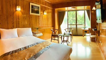 A wooden room with a bed, a desk, and a chair.