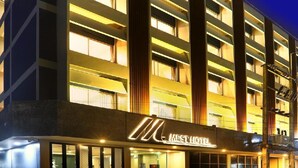 Egy modern, többemeletes szállodai épület, világos ablakokkal és feltűnő „MEST HOTEL” felirattal.