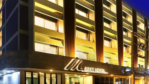 A modern hotel building with multiple floors, illuminated windows, and a prominent 'MEST HOTEL' sign. - Mest Hotel (Phatthalung)