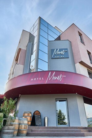 A modern hotel with a curved facade, a prominent sign reading "HOTEL Monet," and a visible entrance with steps leading up to it. - Mirena Hotel (Plovdiv)