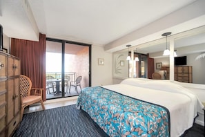 Une chambre d’hôtel avec un lit, une chaise, un bureau, un miroir et un balcon donnant sur un beau paysage.