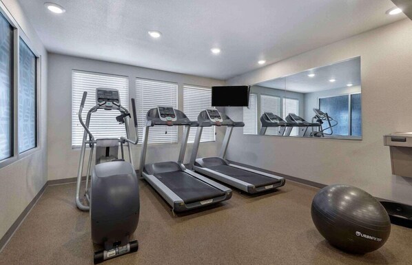 Una palestra con tapis roulant, ellittiche e cyclette.