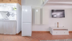 A modern kitchen with a refrigerator, a built-in stove, and a flat-screen TV mounted on the wall. - San Niccolo Loft (Florence)