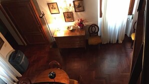Un coin repas avec une table et des chaises en bois, un lustre et des tableaux encadrés accrochés au mur.