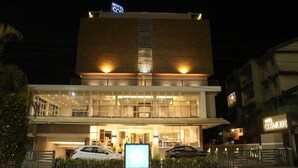 A hotel with a modern design, featuring a prominent entrance with a glass facade and a signboard. - Cosmique Clarks Inn Suites Goa (Margao)