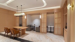 A modern hotel room with a dining area, a sofa, and a small table. - City Comfort INN Kunming Railway Station (Kunming)