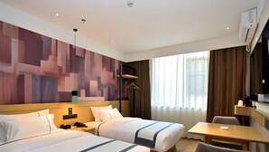 A hotel room with two beds, a desk, a chair, a TV, and a large abstract wall mural. - City Comfort Inn Kunming Railway Station (Kunming)