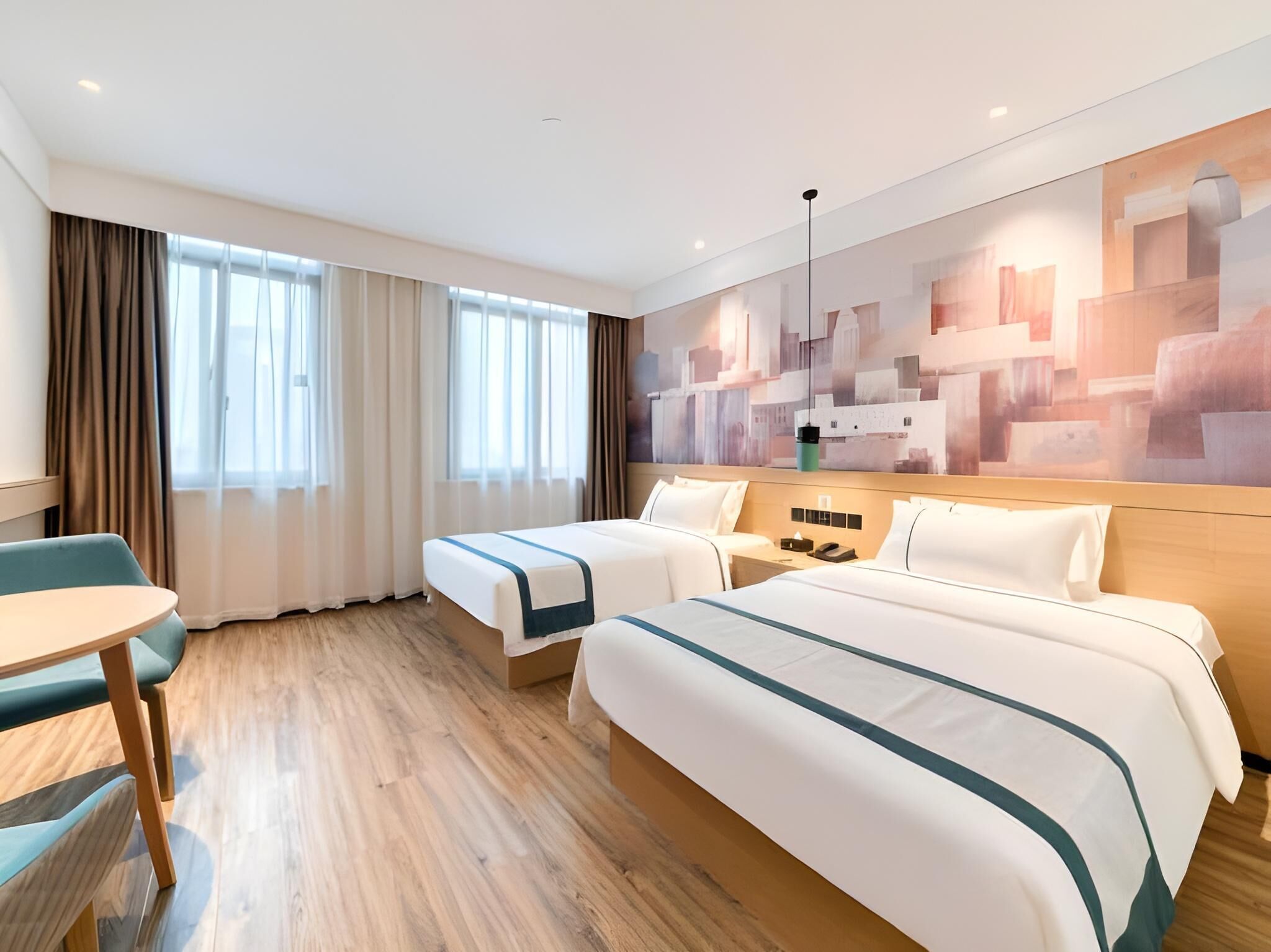 Camera d'albergo con due letti, una scrivania e una sedia.