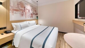 A hotel room with a bed, bedside table, and a wall-mounted TV. - City Comfort Inn Kunming Railway Station (Kunming)