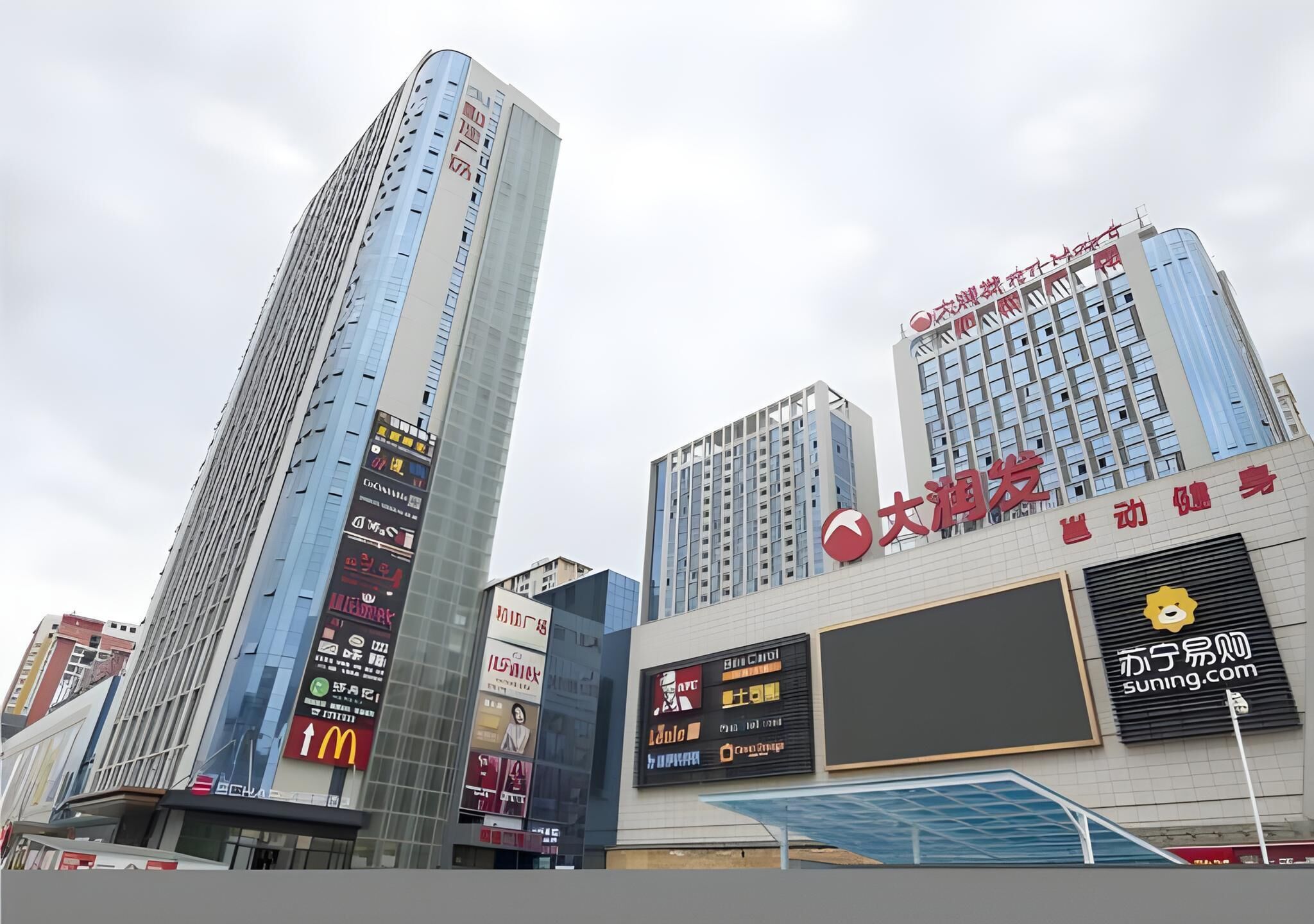 A high-rise building with multiple advertisements and a large digital billboard.