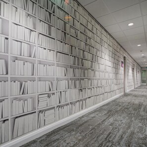 A library with bookshelves lining the walls and a carpeted floor. - Warwick Conferences - Radcliffe House (Coventry)