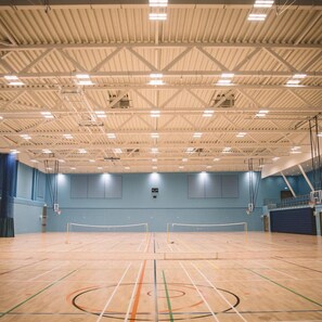An indoor sports hall with a basketball court, a volleyball net, and a climbing wall. - Warwick Conferences - Radcliffe House (Coventry)