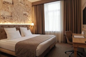 A hotel room with a large bed, a desk, and a map on the wall. - Calvary Hotel and Restaurant Vilnius (Vilnius)