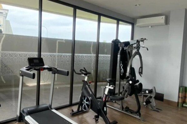 Ein Heimfitnessraum mit Laufband, Ergometer und Ellipsentrainer.