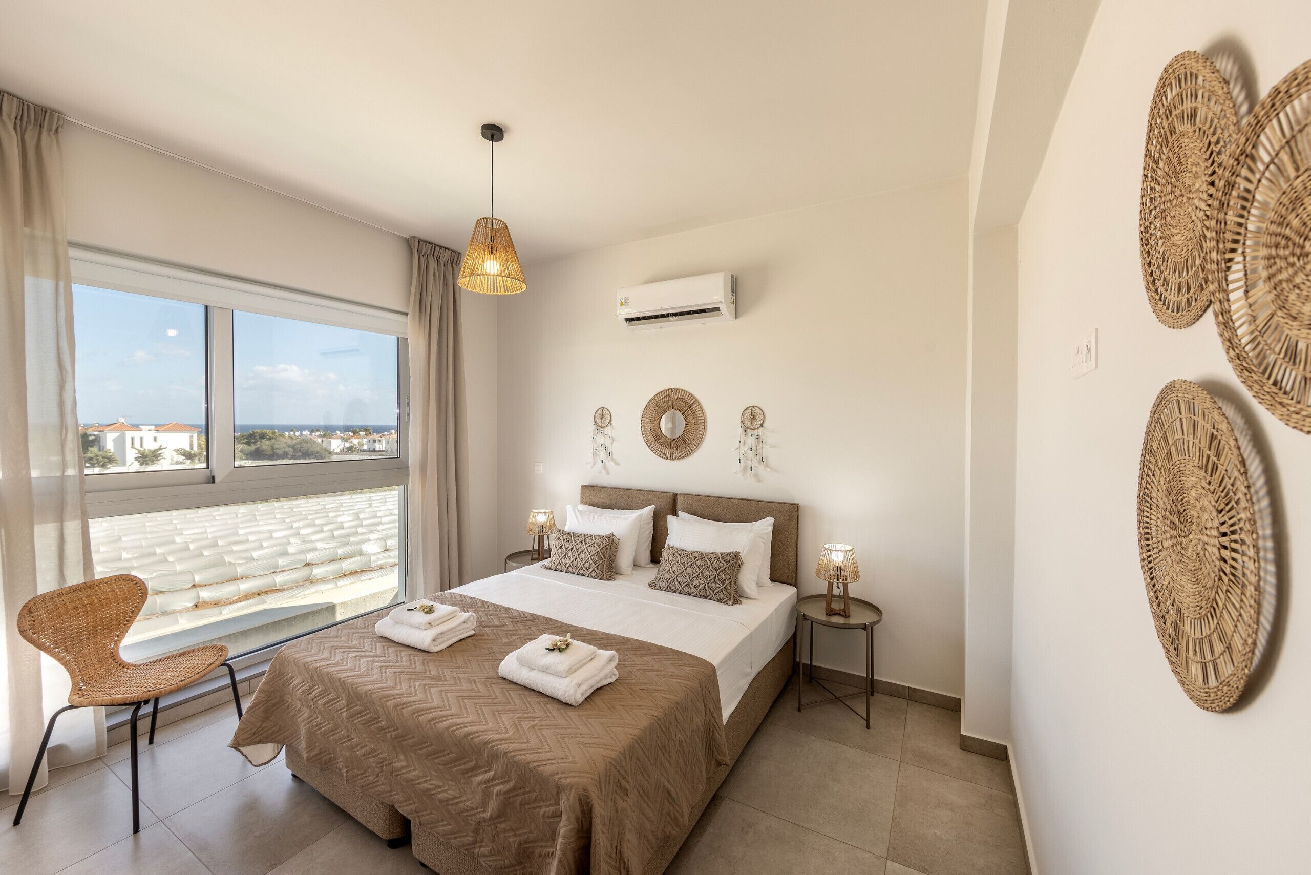 A modern bedroom with a large bed, a view of the city through the window, and a balcony.