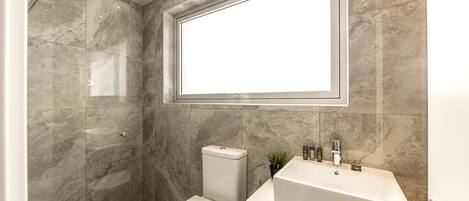 Un baño moderno con ducha, inodoro y lavamanos.