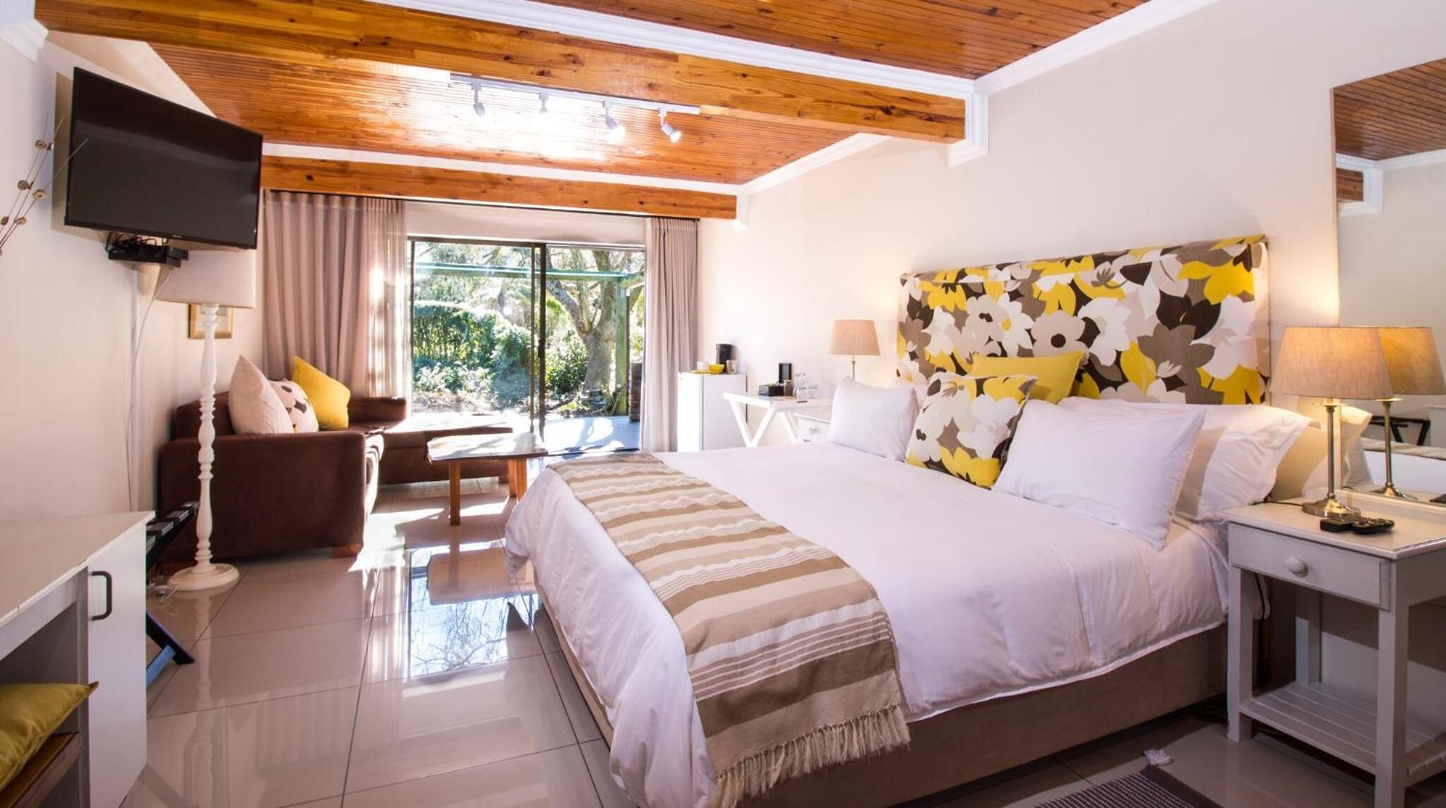 Une chambre d’hôtel moderne équipée d’un grand lit, d’un téléviseur à écran plat, d’un bureau et d’une chaise.