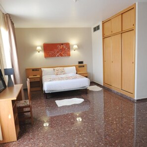 A hotel room with a bed, bedside tables, a desk, a wardrobe, and a wall-mounted artwork. - Maria Rosa (Pedrola)