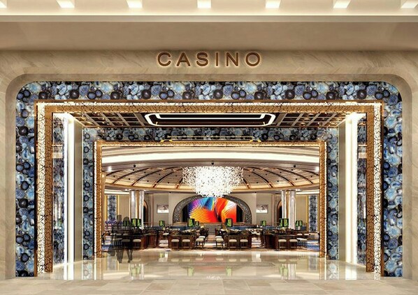 A casino entrance with a marble facade, a chandelier, and a large, colorful digital display. - City of Dreams Mediterranean (Limassol)