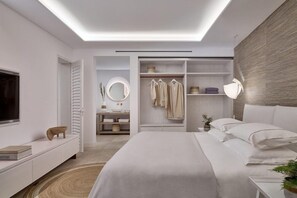 Ein modernes Schlafzimmer mit Bett, Nachttisch und begehbarem Kleiderschrank.