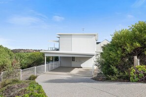 A modern two-story house with a covered driveway and a fenced yard. - Beach by the Dunes: Relaxing, contemporary beach house, walk to beach and river (Goolwa Beach)