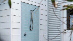 A showerhead mounted on a wall with a tiled shower enclosure. - Beach by the Dunes: Relaxing, contemporary beach house, walk to beach and river (Goolwa Beach)
