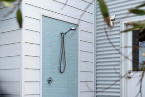 A showerhead mounted on a wall with a tiled shower enclosure. - Beach by the Dunes: Relaxing, contemporary beach house, walk to beach and river (Goolwa Beach)