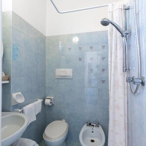 A bathroom with a toilet, bidet, sink, shower, and a towel rack. - Hotel Sole (Cattolica)