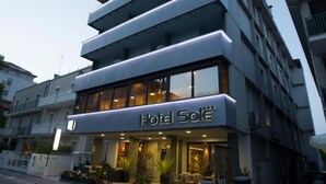 A multi-story hotel with a prominent 'Hotel Soleil' sign, large windows, and a ground-level entrance with outdoor seating. - Hotel Sole (Cattolica)