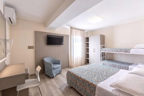 A hotel room with a desk, chair, TV, bunk beds, and a wardrobe. - Hotel Sole (Cattolica)