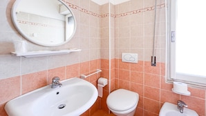 A bathroom with two sinks, a toilet, a mirror, and a window. - Hotel Giulio Cesare (Cattolica)