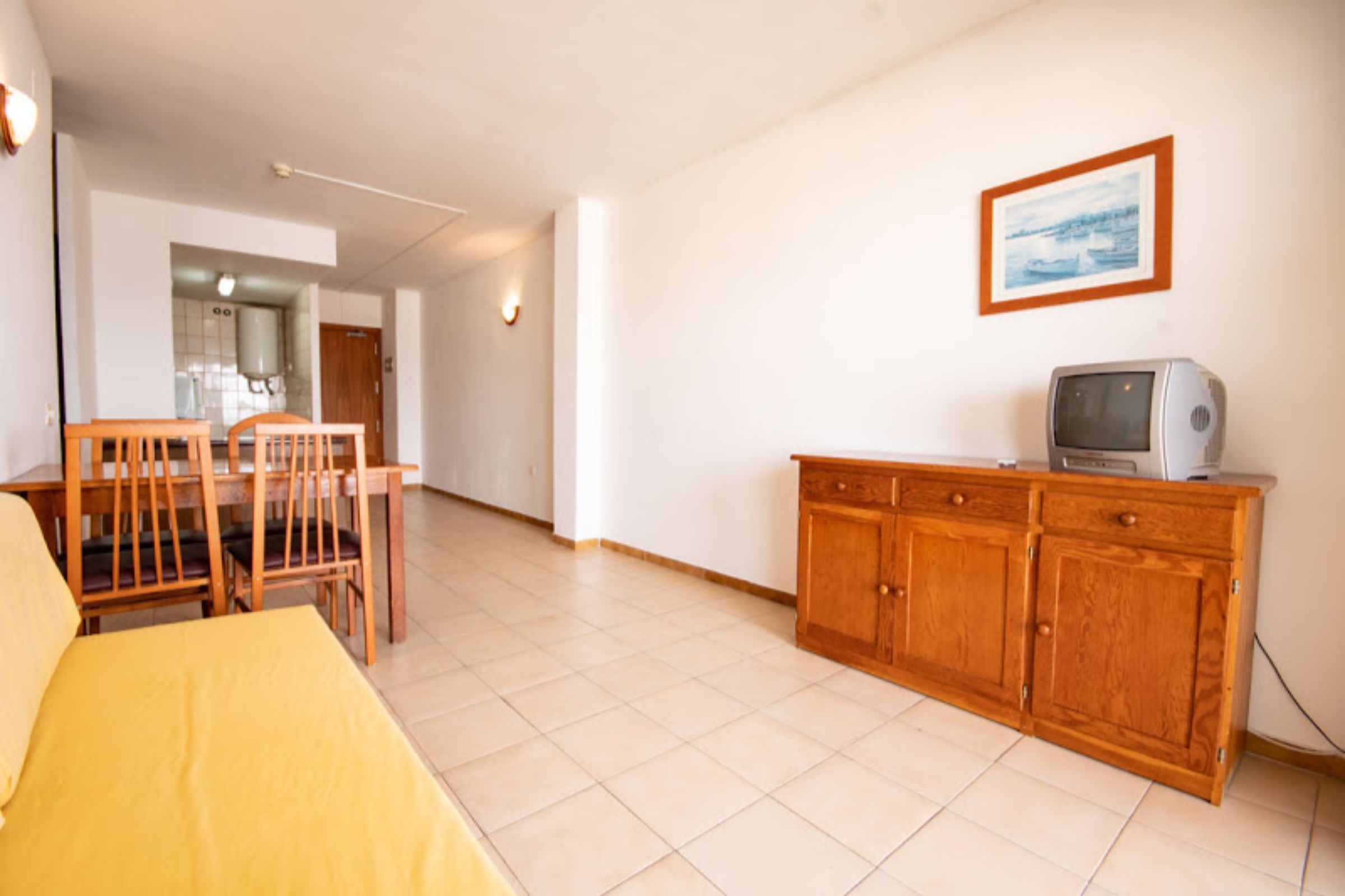 Una stanza con un letto, mobili in legno, una televisione e un quadro appeso al muro.