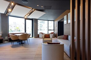 Un salon moderne avec un coin repas, de grandes fenêtres et une vue sur la ville.