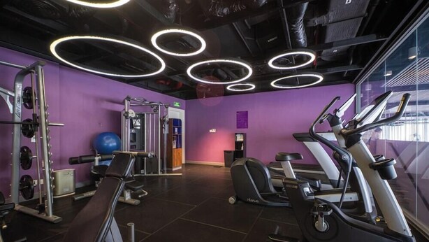 A gym with elliptical machines, weightlifting equipment, and a blue exercise ball. - Wink Hotel Danang Riverside (Da Nang)