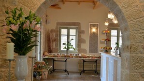 Una cocina rústica con paredes de piedra, una isla central con exhibición de frutas y un rincón de estar acogedor.