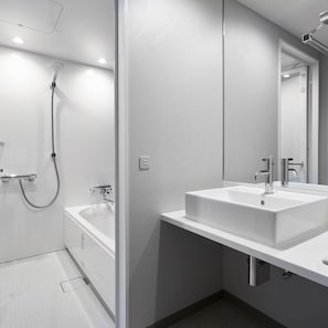 Une salle de bain moderne avec une baignoire, une douche et un lavabo.