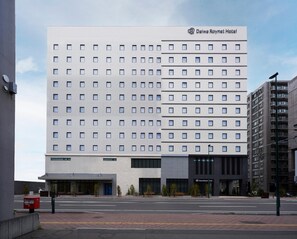 Ein modernes Hotelgebäude mit einer flachen Fassade, zahlreichen Fenstern und einem gut sichtbaren Hotelschild.
