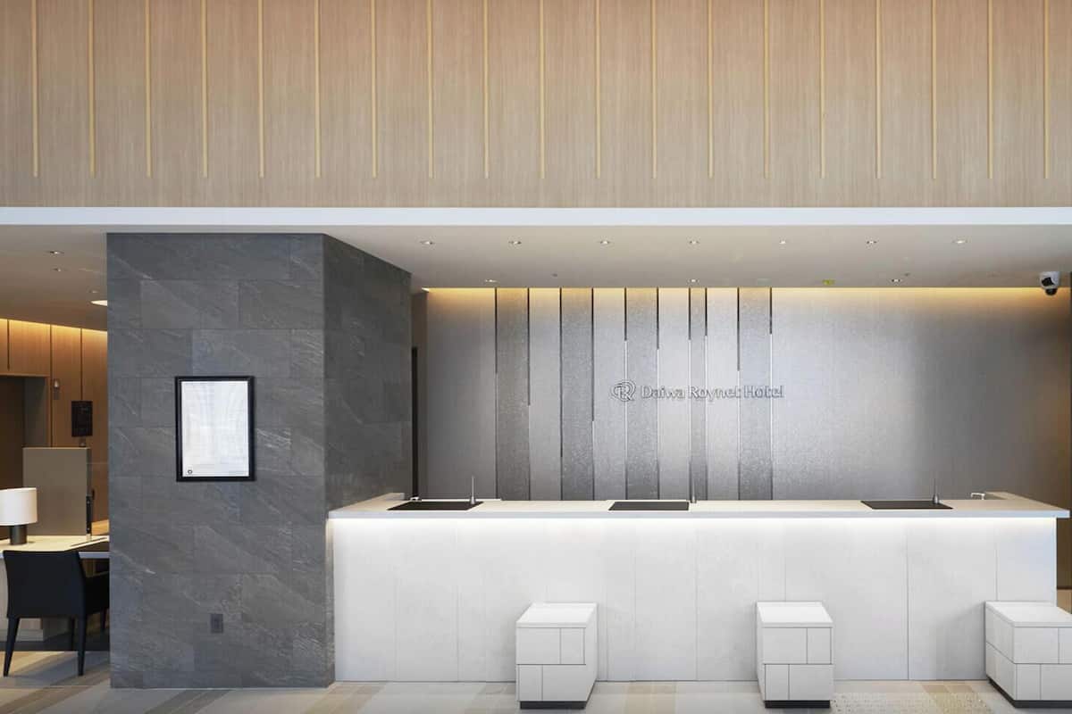 A modern reception desk with a digital screen, a logo, and a sign for Daiwa House Group.