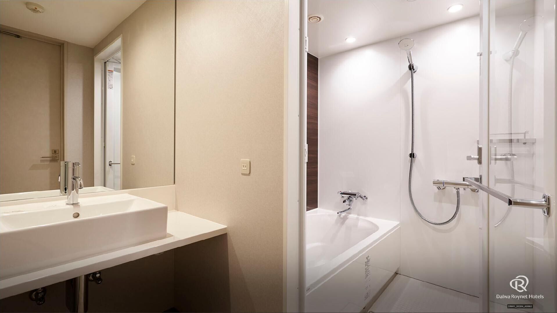 A modern bathroom with a large mirror, a sink, a shower with a glass door, and a bathtub.