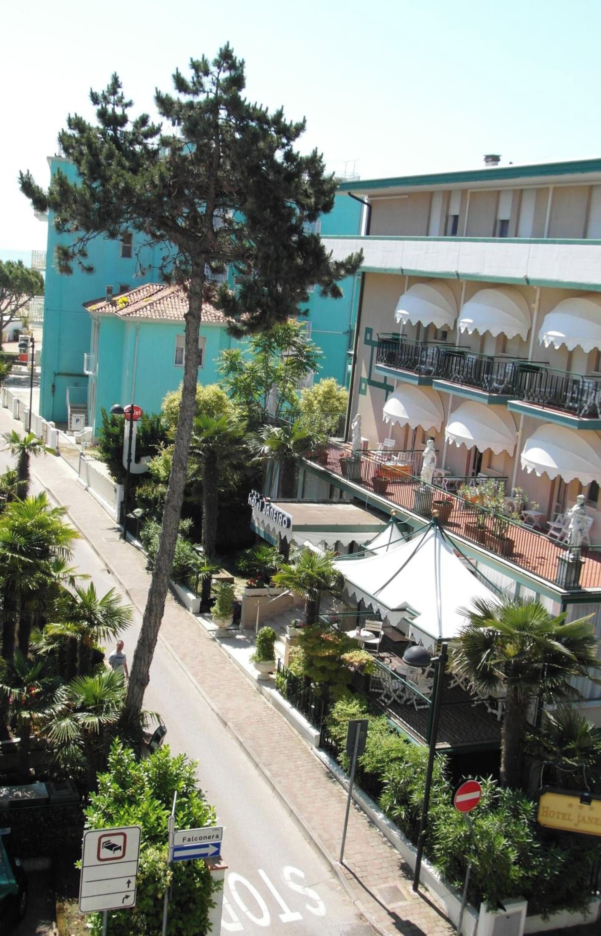 Un hôtel avec un balcon, une rue avec un panneau de signalisation et un panneau indiquant « Falconera ».